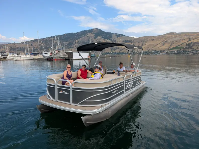 Family relaxing on a pontoon boat on an Okanagan lake